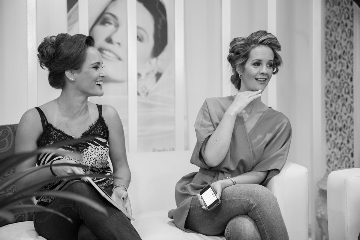 Noiva e madrinha sorrindo no making of