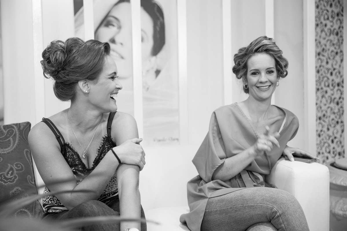 Noiva e madrinha sorrindo no making of