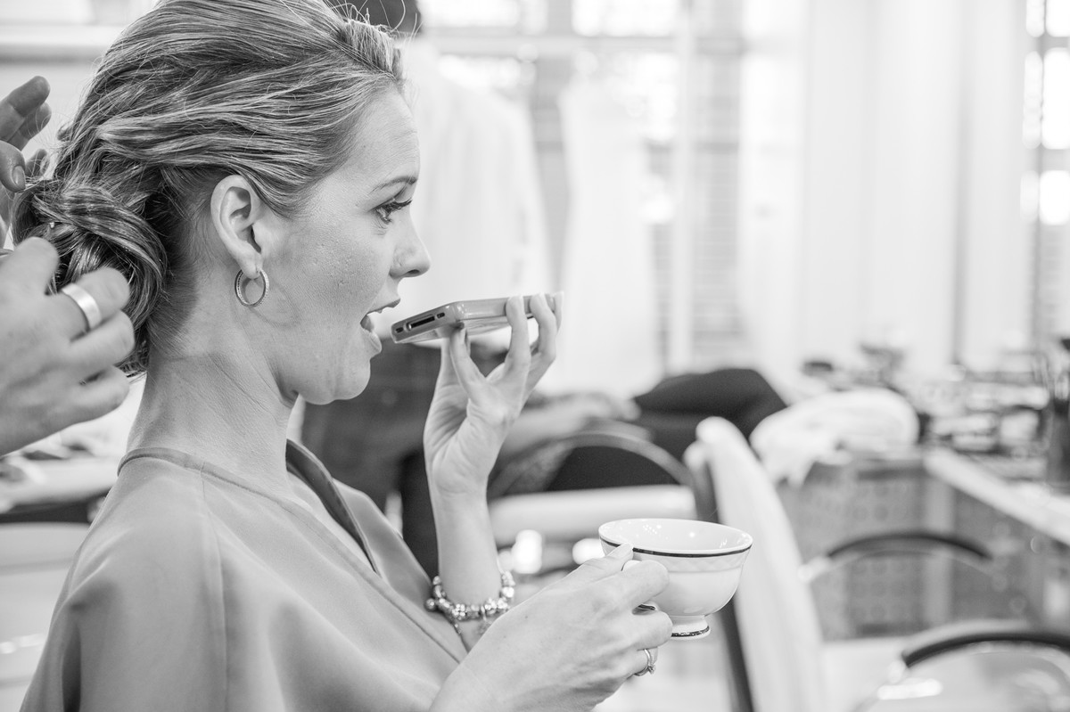 Noiva tomando café e falando ao celular no making of