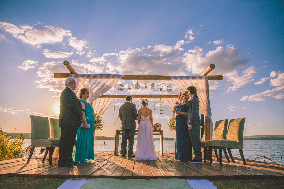 Noivos na cerimônia do casamento com por do sol
