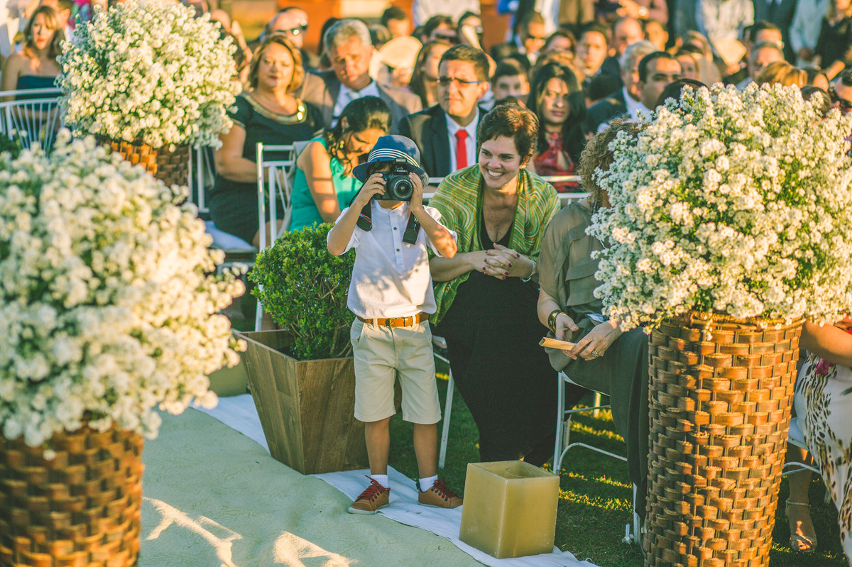 Criança fotografando com câmera na cerimônia do casamento