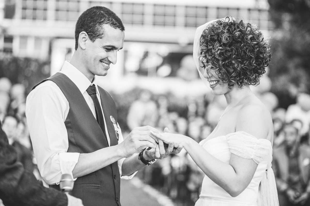 Noivo colocando a aliança na noiva na cerimônia do casamento