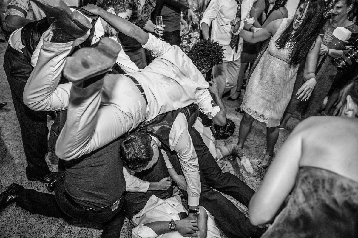 Padrinhos tentando pegar Whisky jogado pelo noivo na recepção do casamento