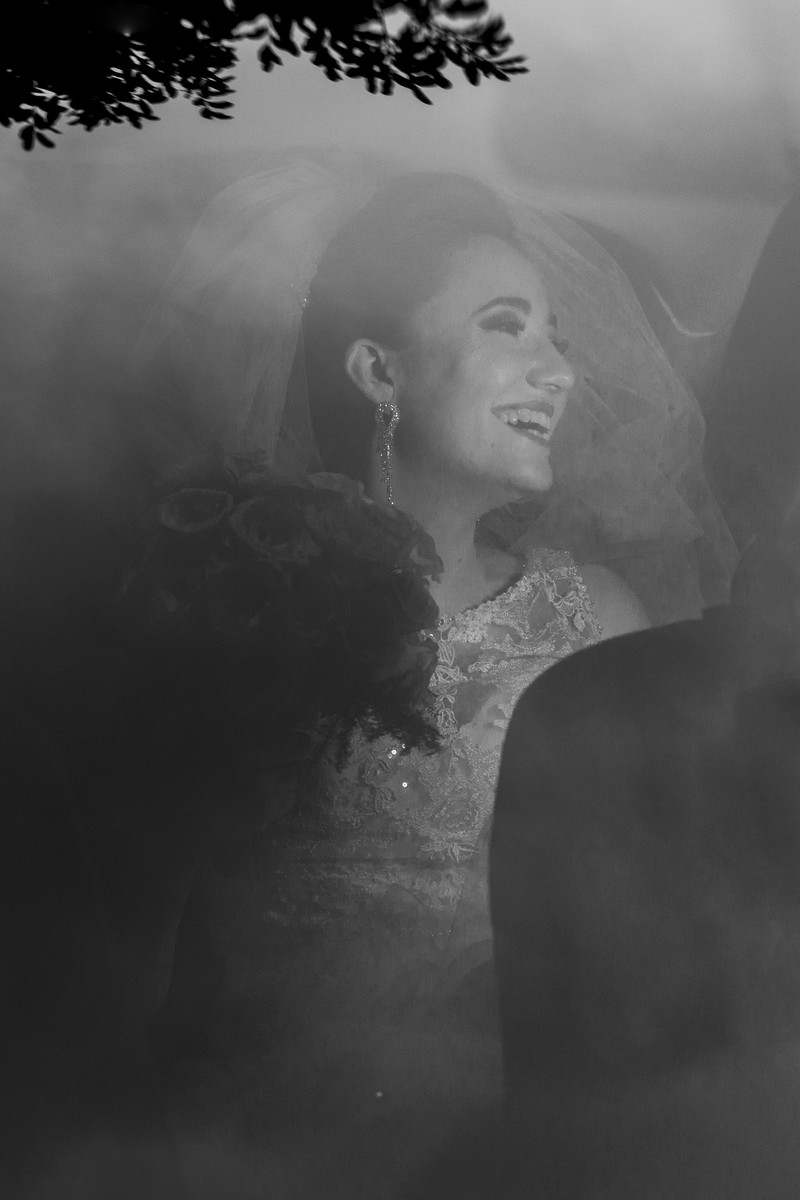 Noiva com buquê sorrindo no carro