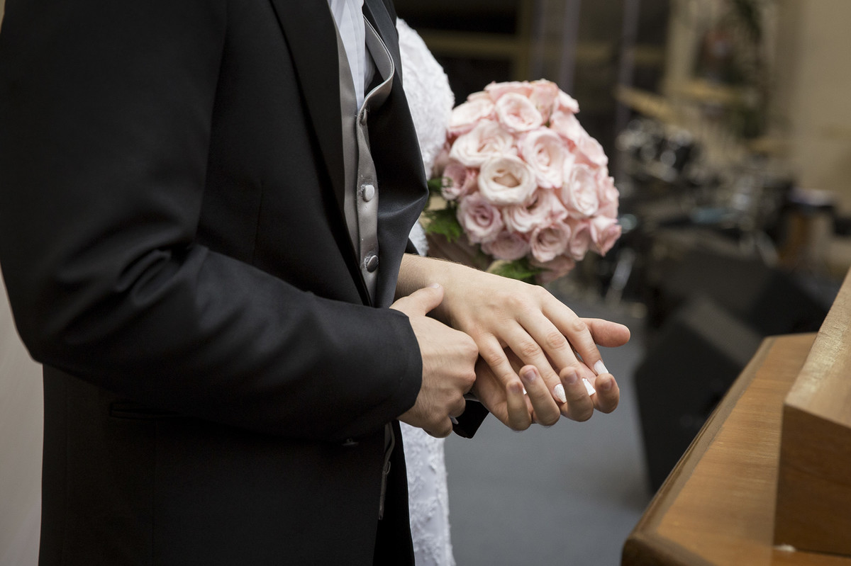 Noivo segurando a mão da noiva na cerimônia