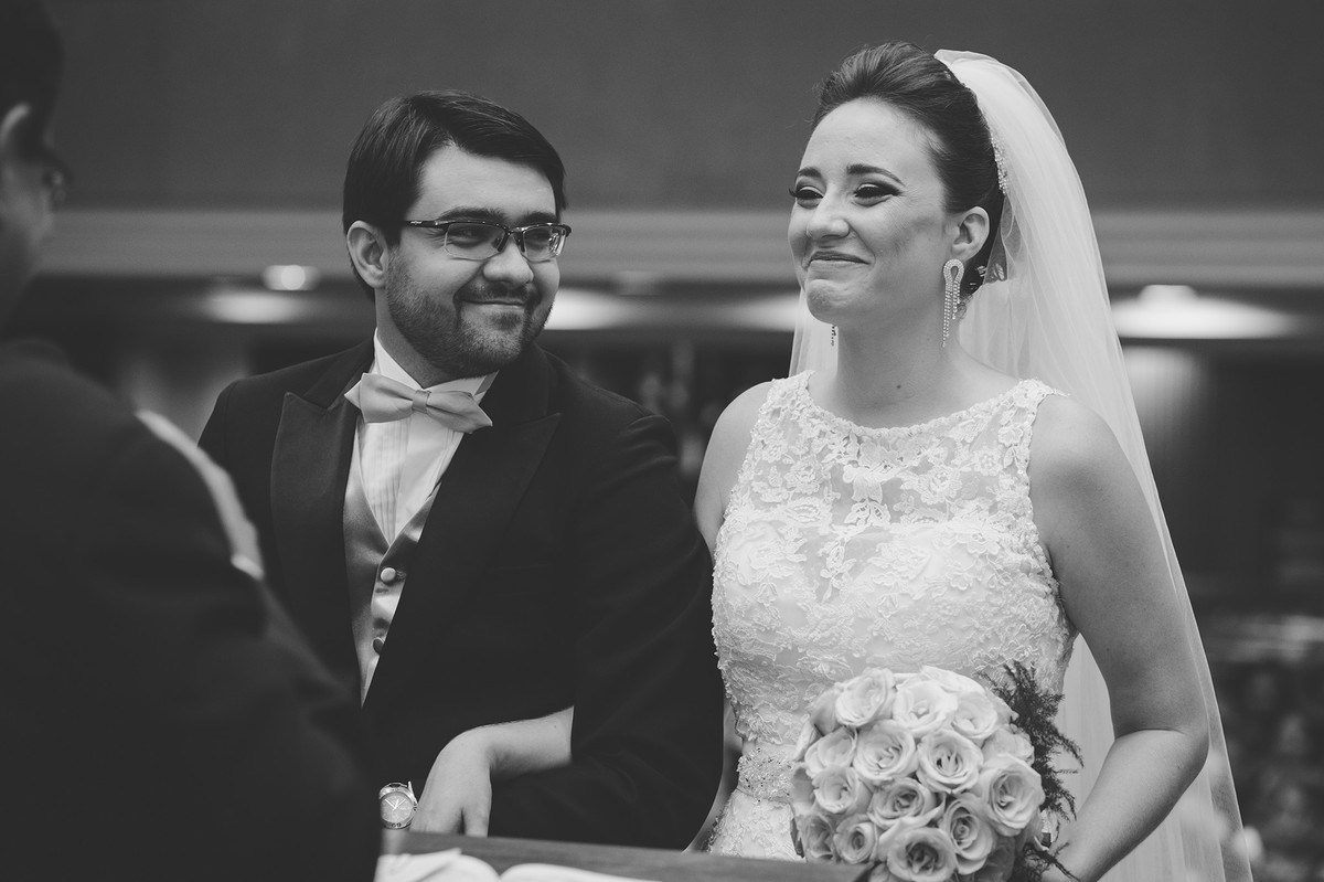 Noiva sorrindo e noivo olhando pra noiva na cerimônia de casamento
