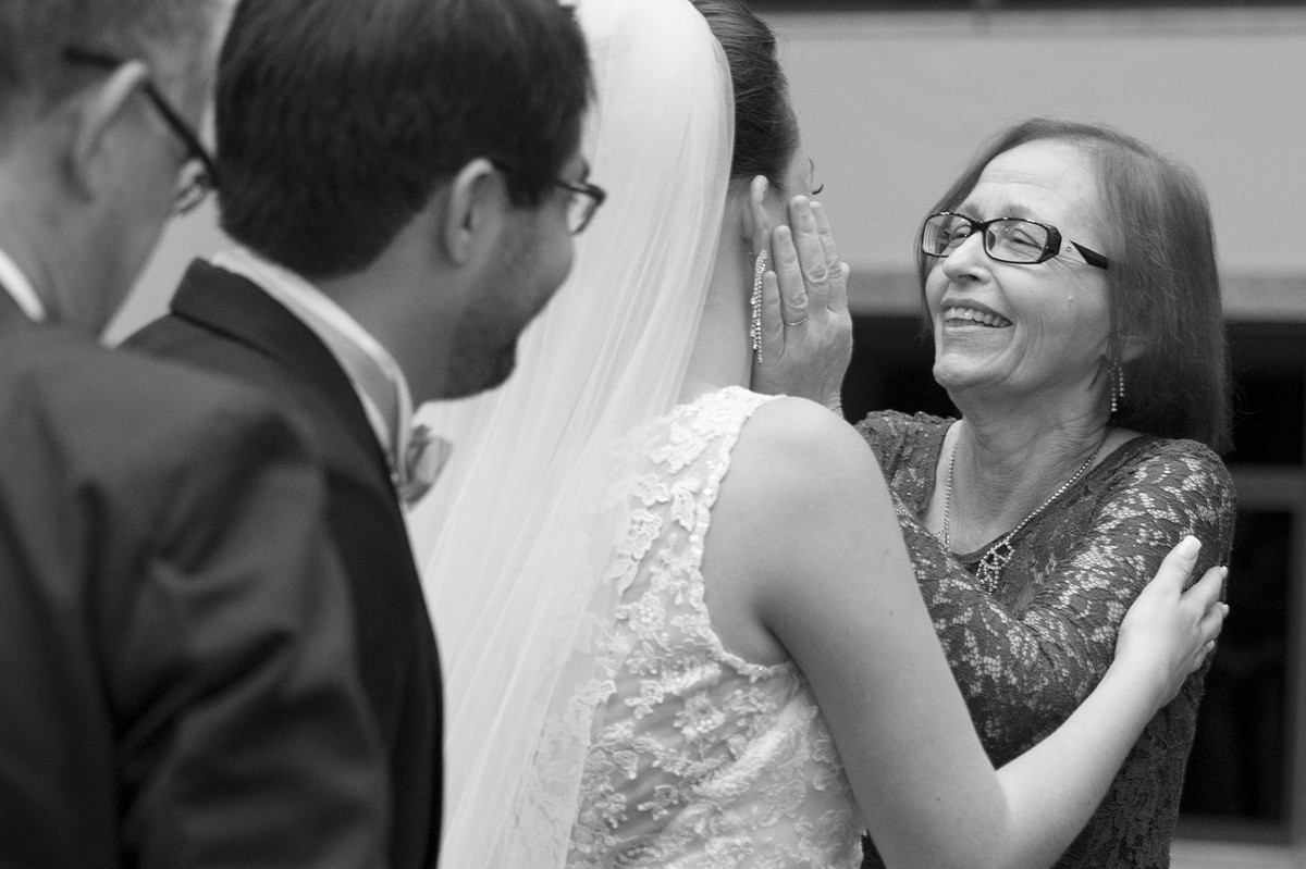 Mãe do noivo fazendo carinho no rosto da noiva na cerimônia do casamento