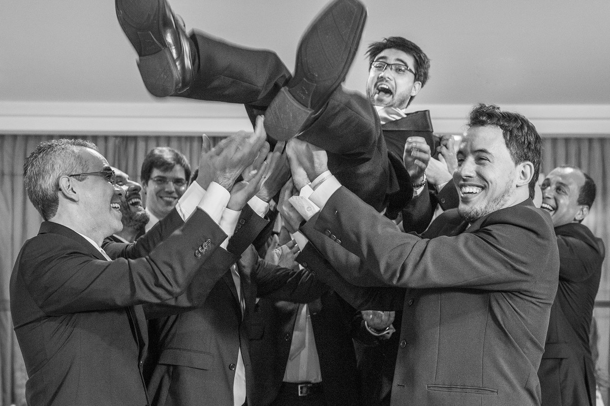 Padrinhos jogando noivo pra cima na recepção do casamento