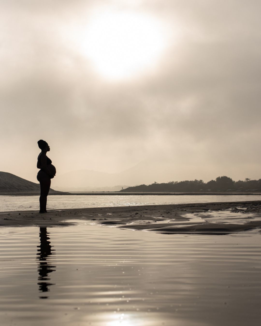 silhueta de gestante durante ensaio praia