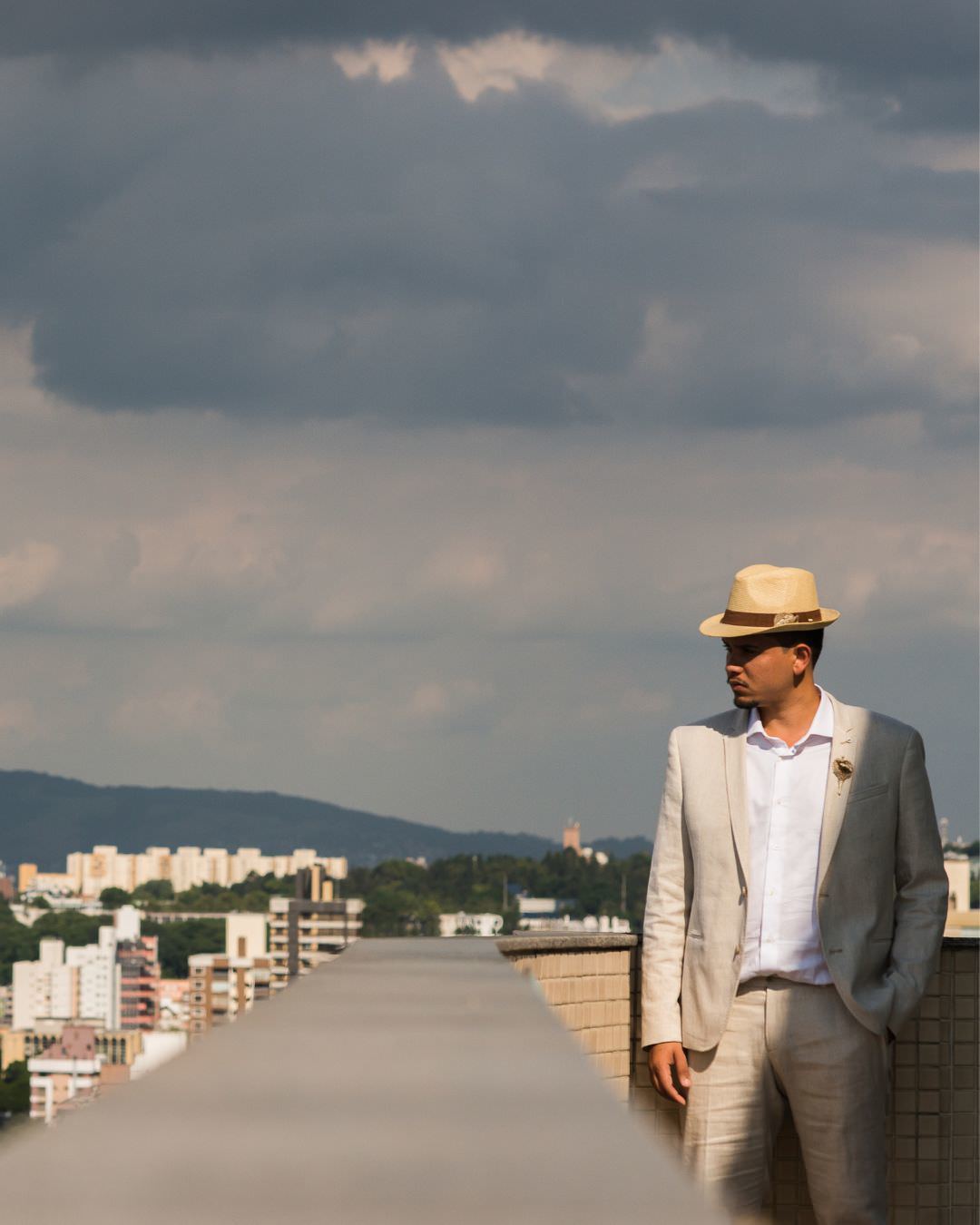 retrato noivo de chapeu panama com cidade de porto alegre ao fundo