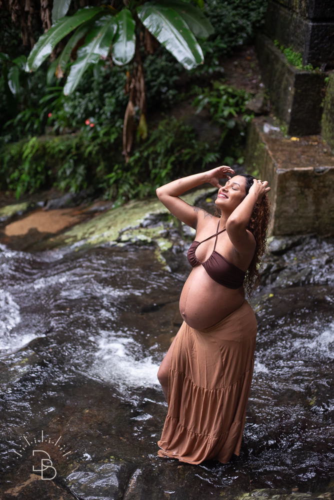 gestante sorrindo durante ensaio na cachoeira