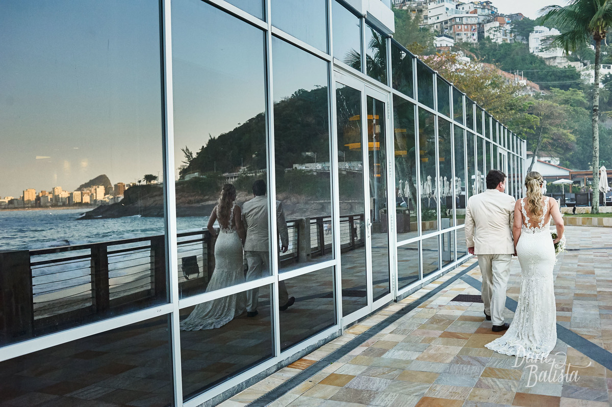 noivos caminhando para a praia do leblon durante o por-do-sol