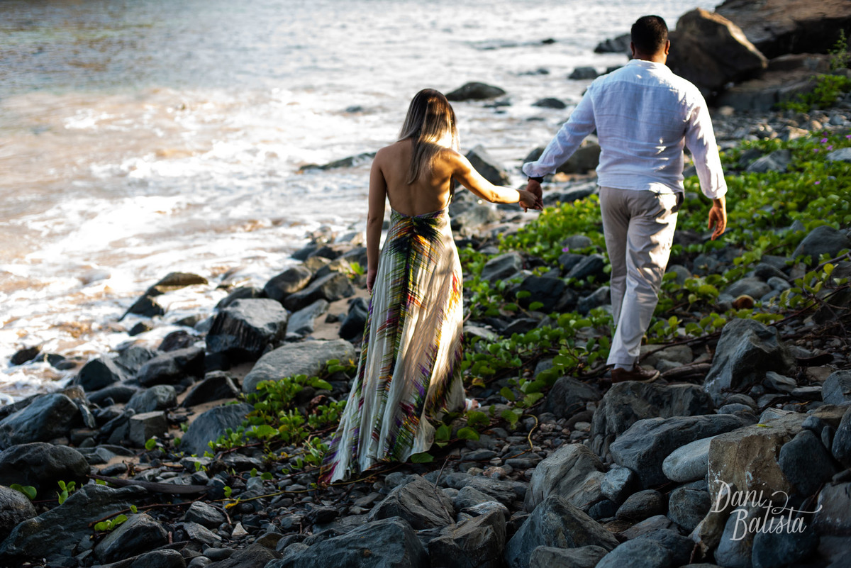 casal caminhando nas pedras durante ensaio fotografico em fernando de noronha