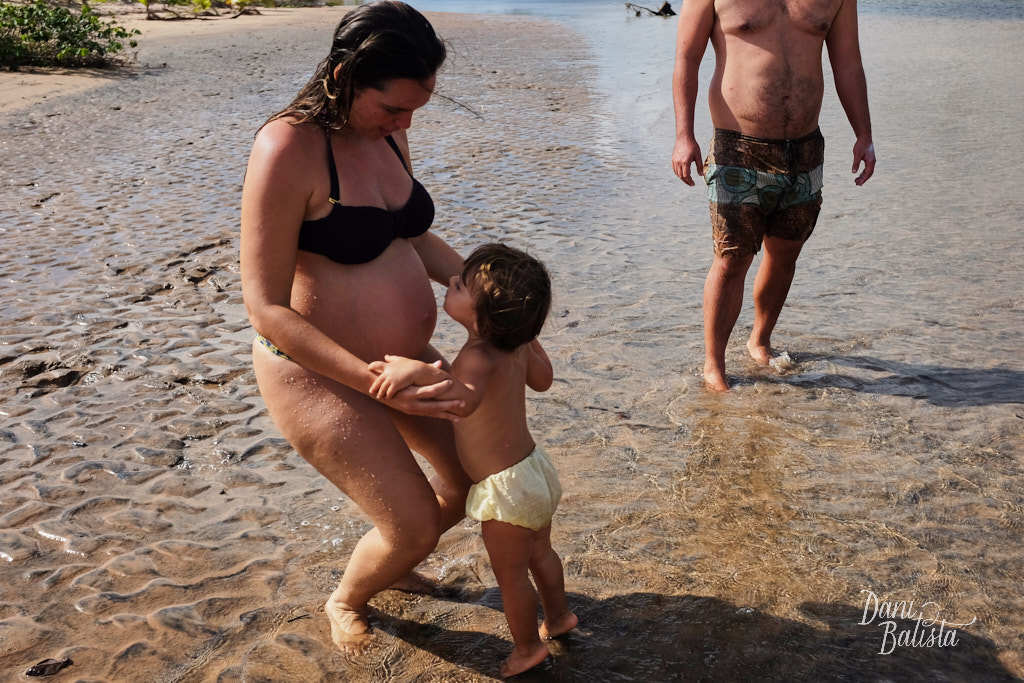 filha beijando a barriga da mãe em ensaio de gestante em Piracanga