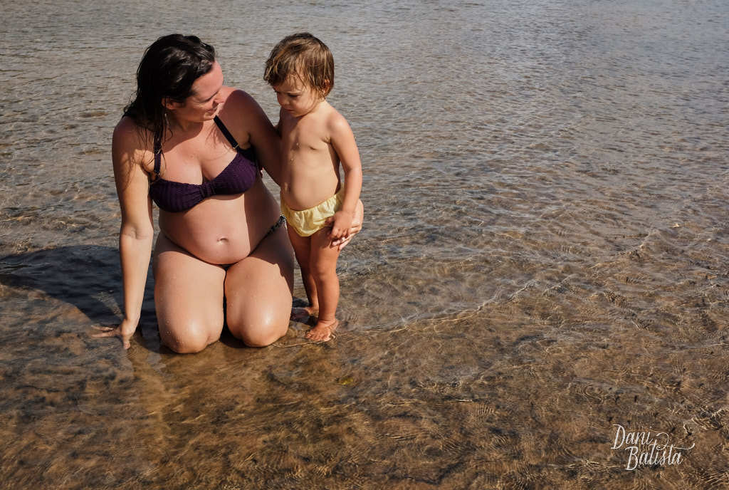 gestante brincando com a filha no rio em piracanga durante ensaio de fotos