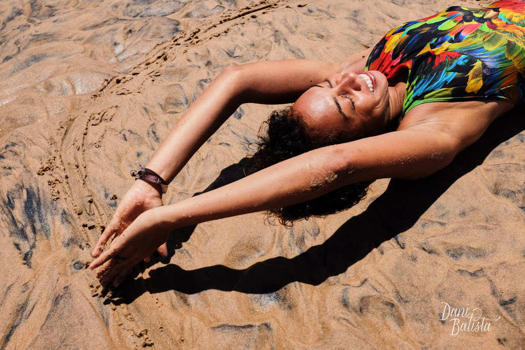 modelo sorrindo deitada no sol na areia do rio piracanga