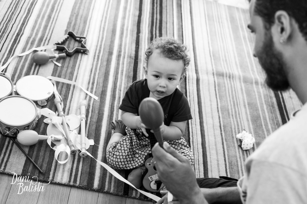 bebê brincando com o pai e instrumentos musicais no aniversario infantil de 1 aninho