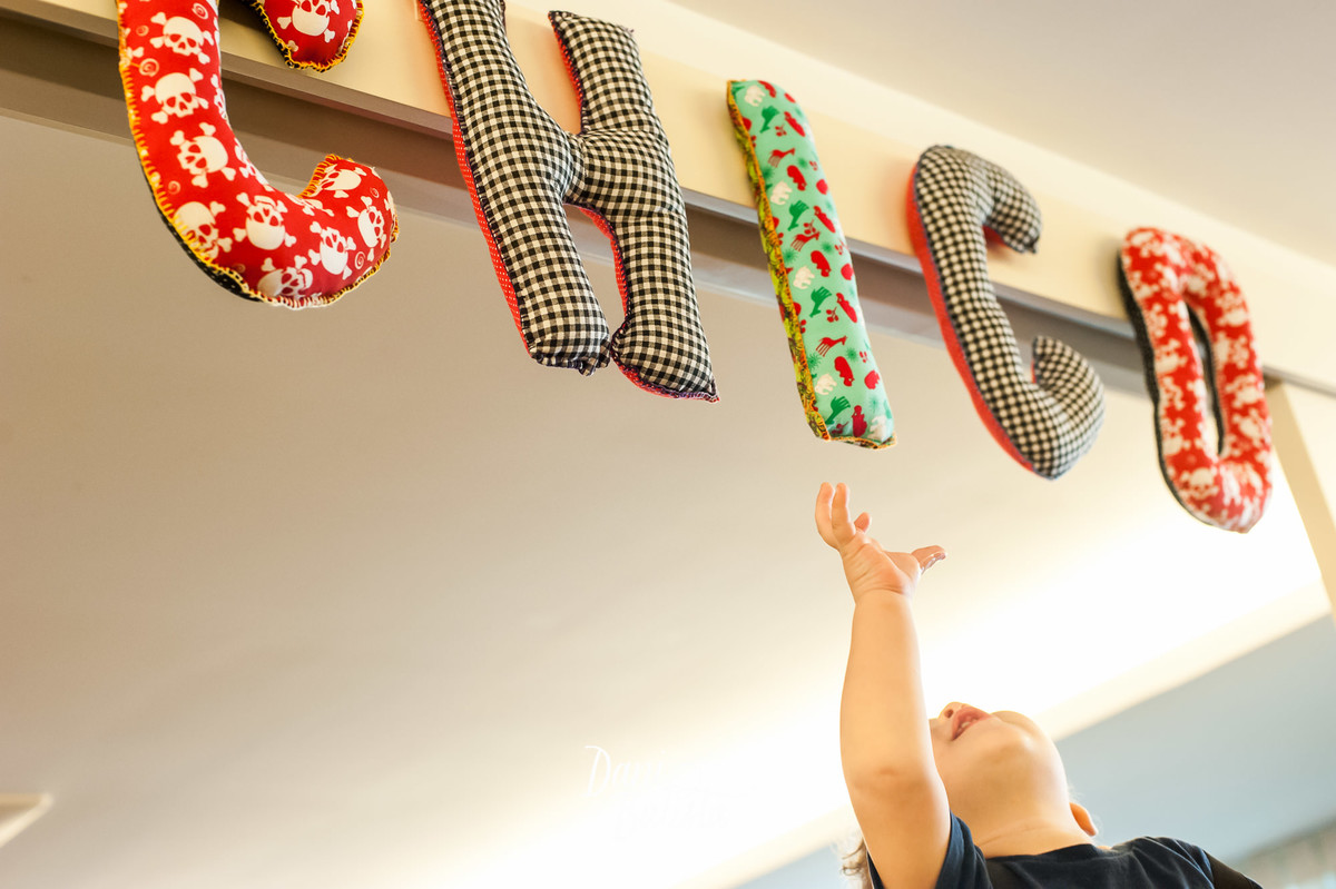 bebê brincando com as letras do seu nome no aniversario infantil de 1 aninho