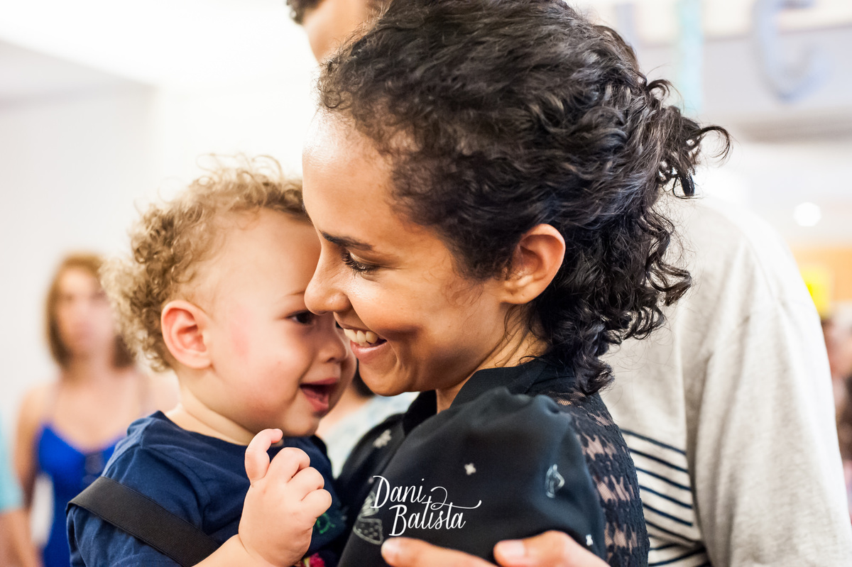 bebê sorrindo no colo da mãe 
 no aniversario infantil de 1 aninho