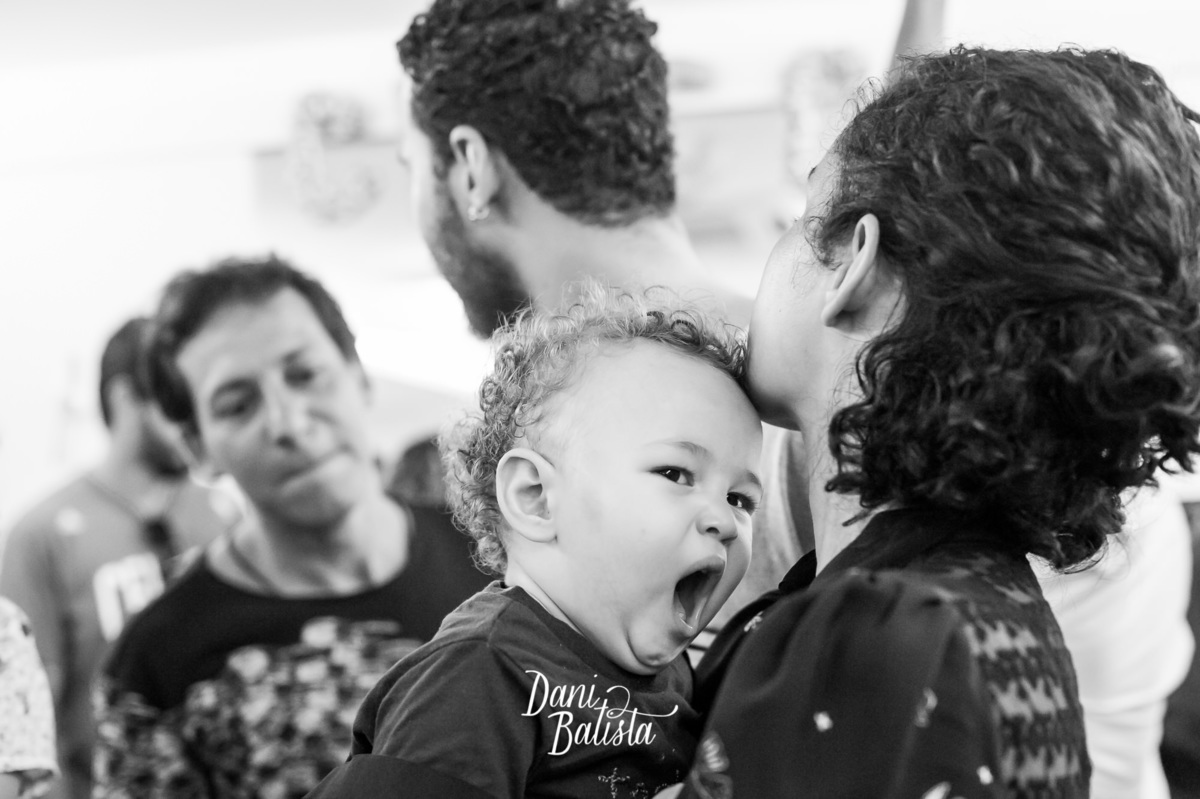 bebê com sono no colo da mãe 
 no aniversario infantil de 1 aninho