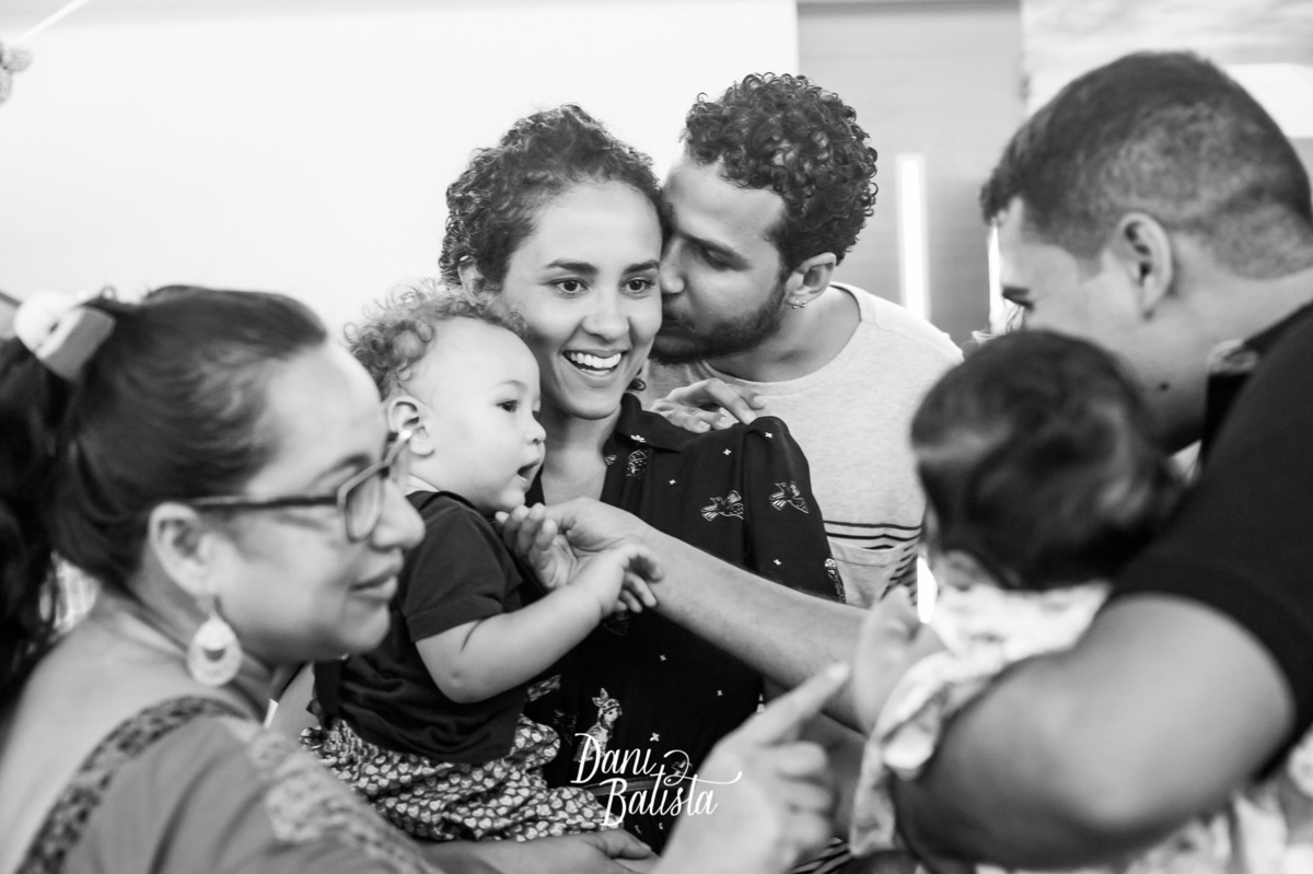 bebê no colo da mãe com convidados 
 no aniversario infantil de 1 aninho