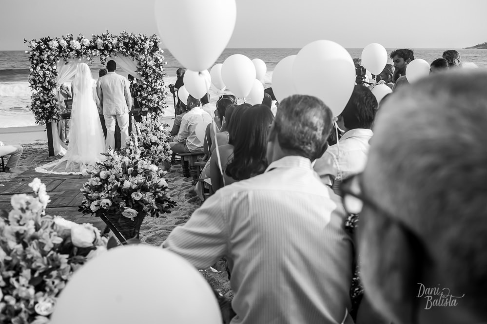 noivos no altar e detalhes dos balões brancos durante cerimonia de casamento ao ar livre na praia do recreio