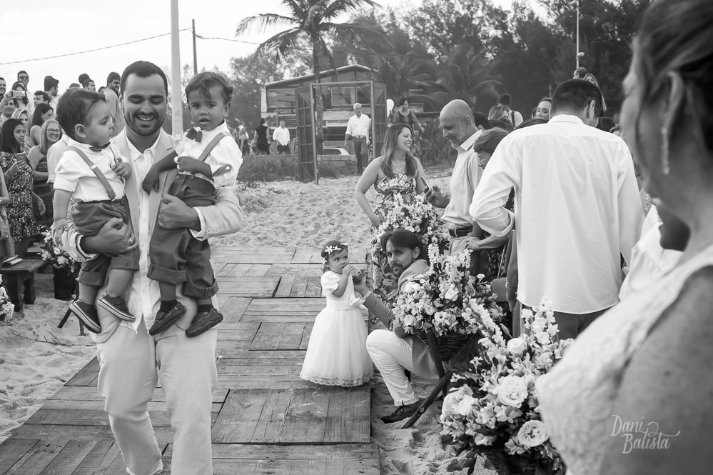 noivo pegando os pajens no colo na cerimonia de casamento ao ar livre na praia do recreio