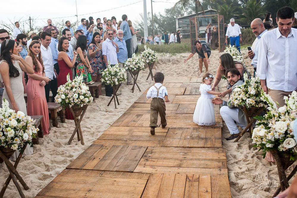 pajem correndo durante o cortejo para cerimonia de casamento ao ar livre na praia do recreio