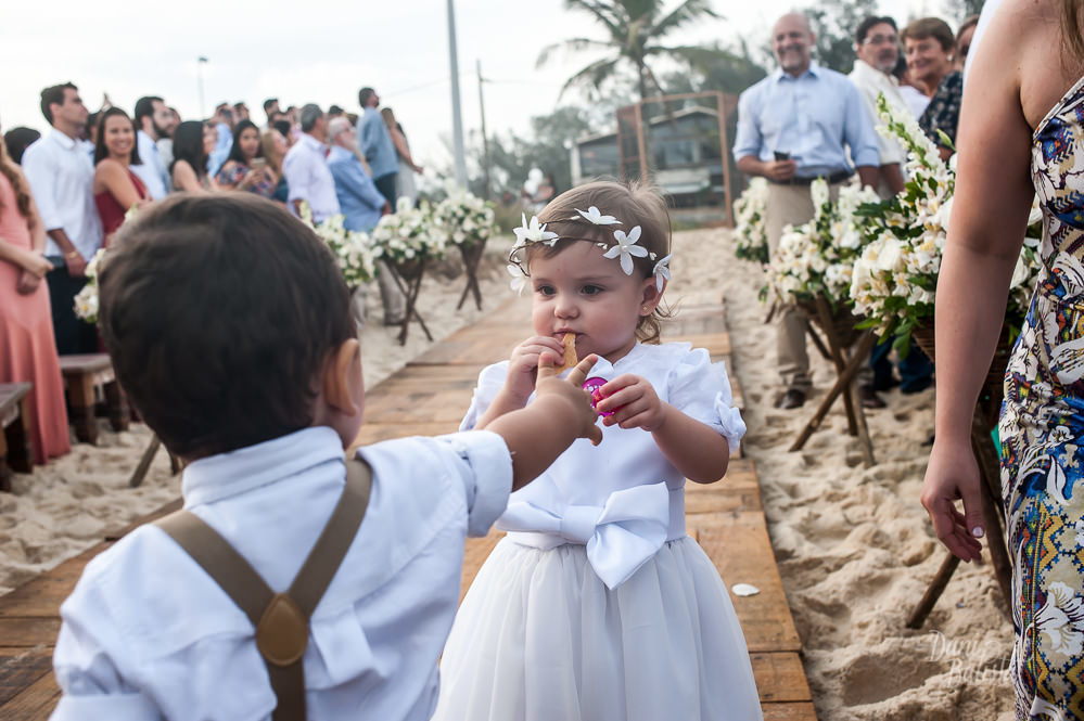 pajem dando biscoito para daminha na cerimonia de casamento ao ar livre na praia do recreio