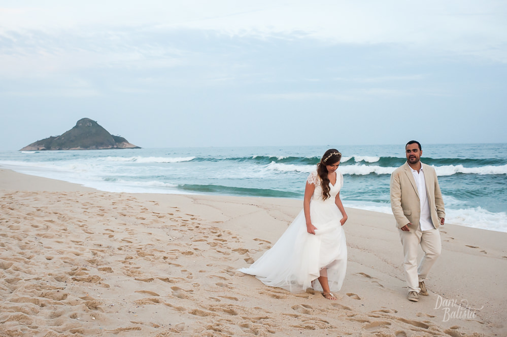 noivos caminhando na praia do recreio após cerimônia diurna