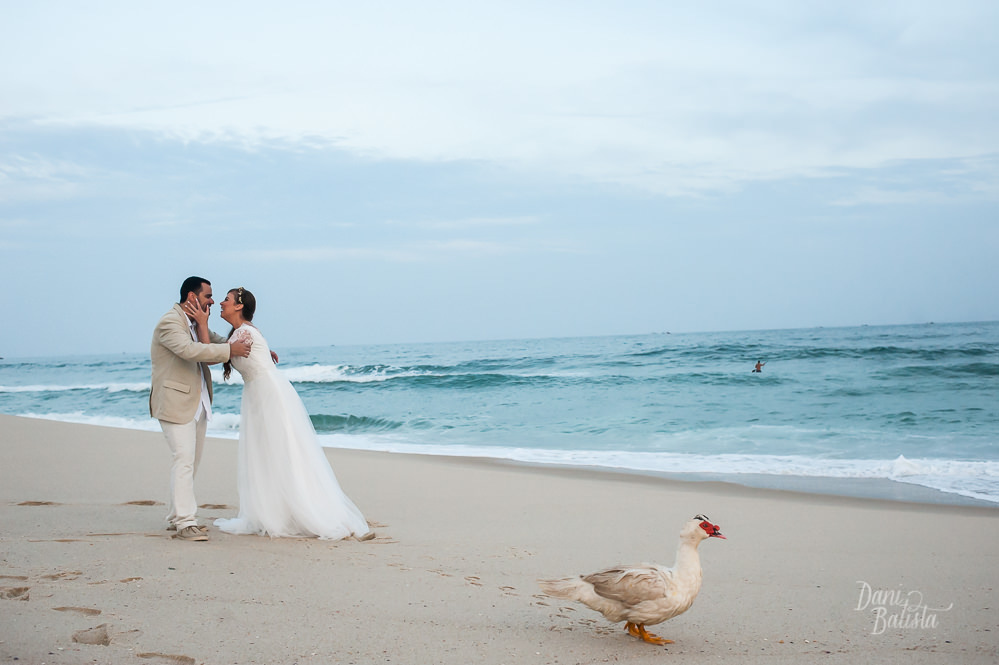 noiva beijando o noivo e pato nas fotos depois de casamento ao ar livre na praia do recreio