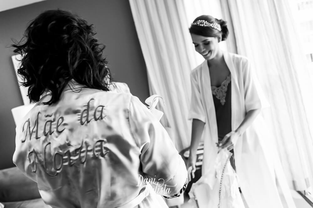 noiva sorrindo colocando o vestido de noiva da pronovias durante os preparativos