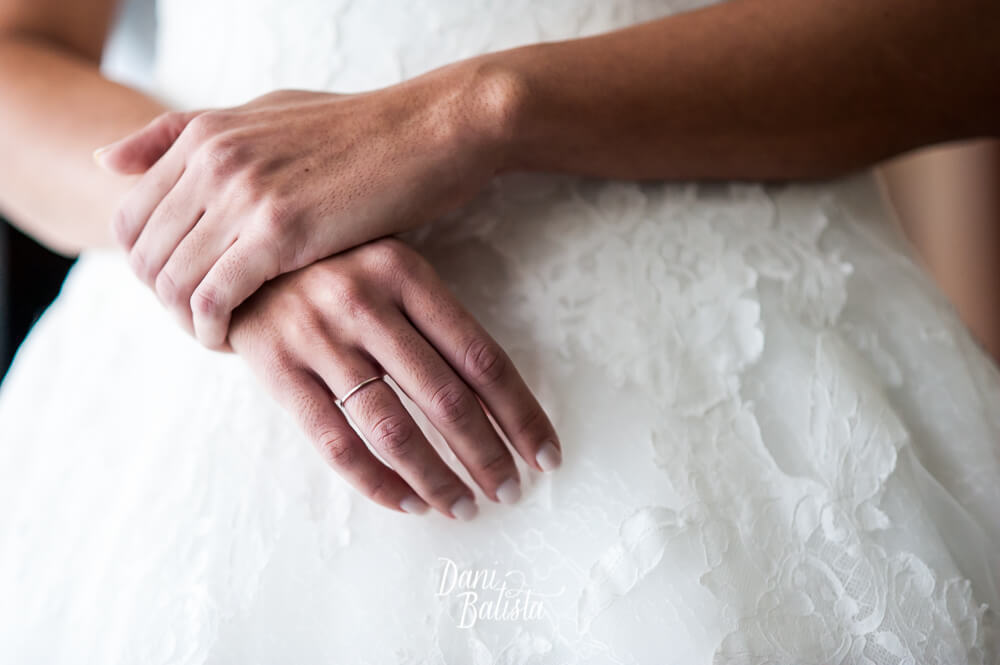 detalhe do anel de noivado e vestido de renda da pronovias