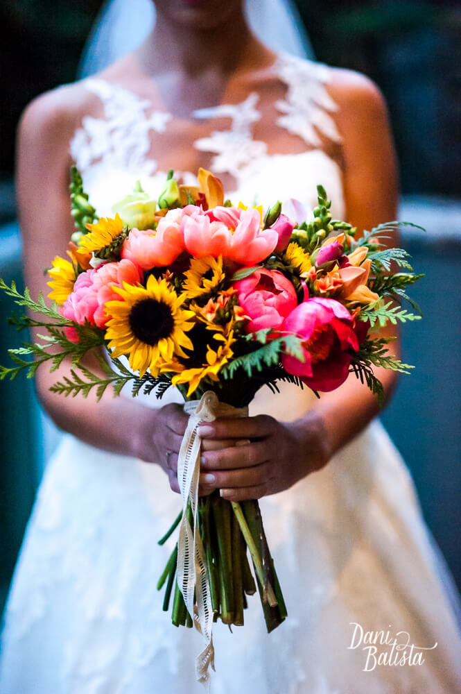 detalhe do bouquet de noiva colorido e desconstruído com girassol e peônias rosas