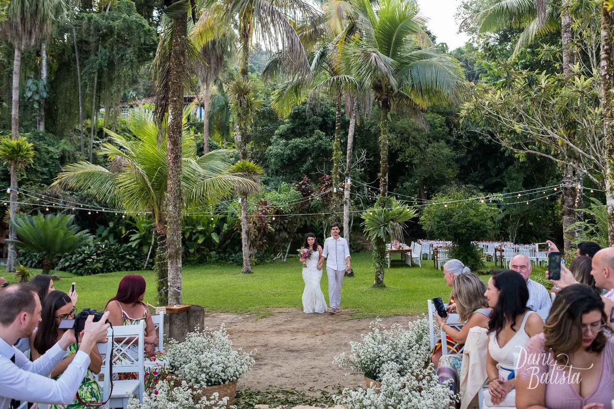 noiva chegando com o filho durante a cerimonia de casamento na praia na pousada enseada do jatoba em paraty