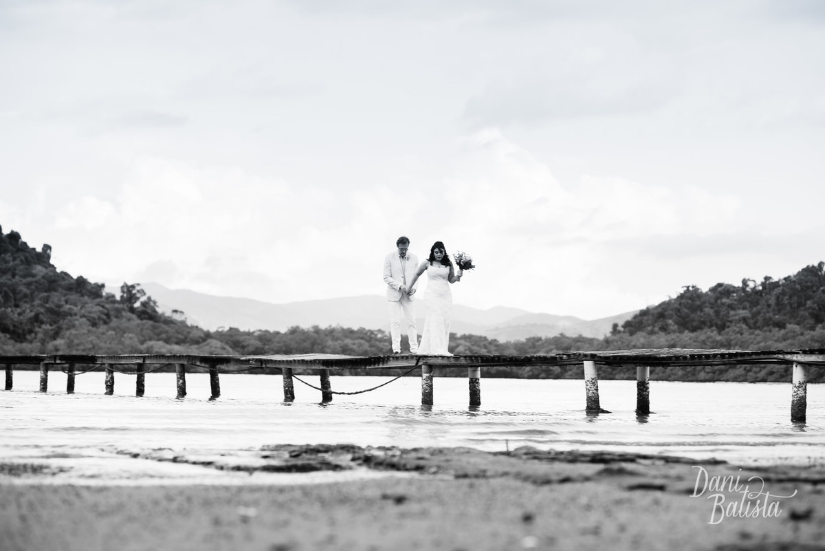 noivos caminhando no deck da praia no casamento diurno na pousada enseada do jatoba em paraty