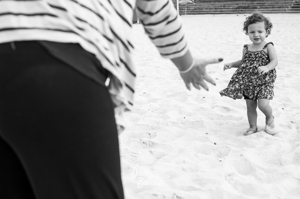 filha correndo para a mãe durante ensaio fotografico de gestante praia leblon