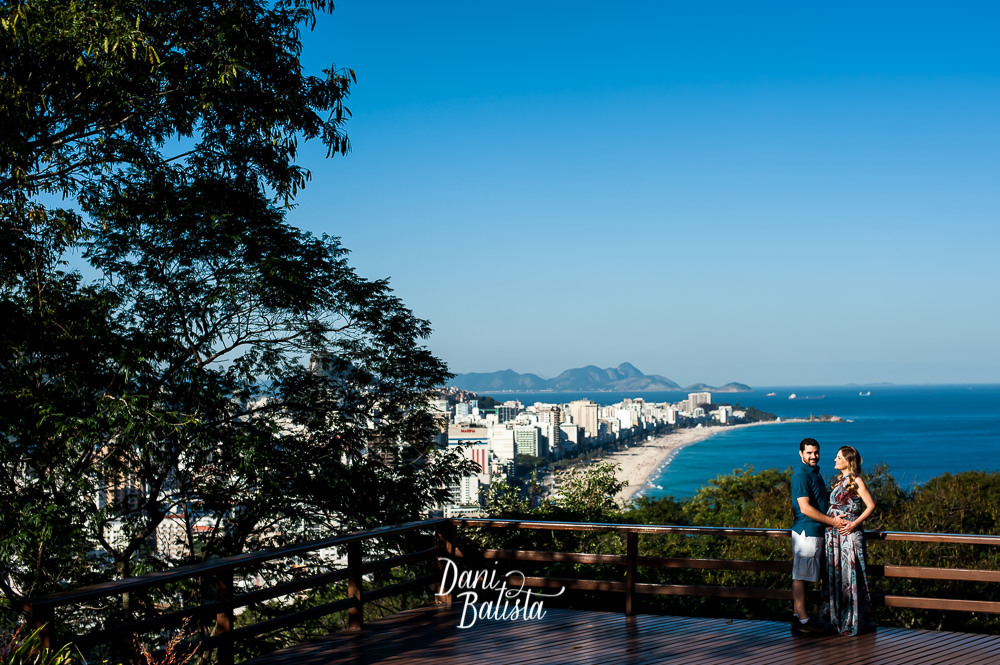 casal durante ensaio fotográfico de gestante com a praia do leblon ao fundo