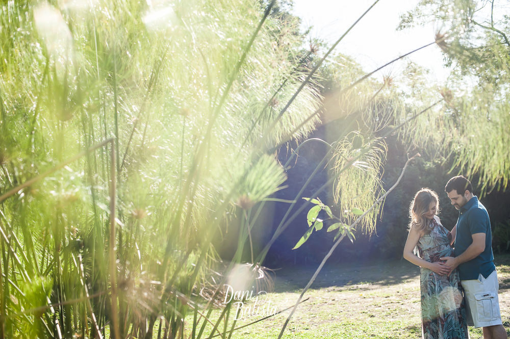 casal admirando a barriga no ensaio fotográfico de gestante no parque do leblon