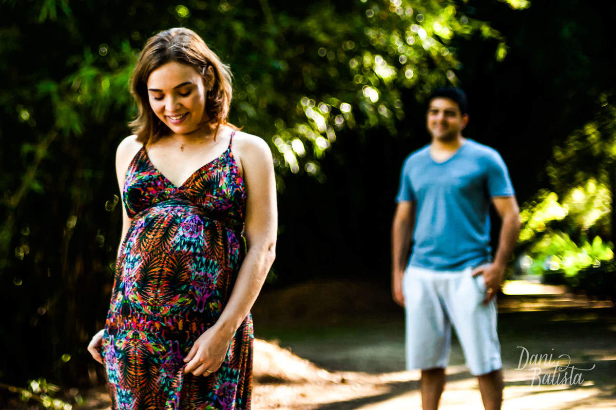 gestante dançando com vestido florido durante ensaio fotográfico no jardim botânico do rio de janeiro