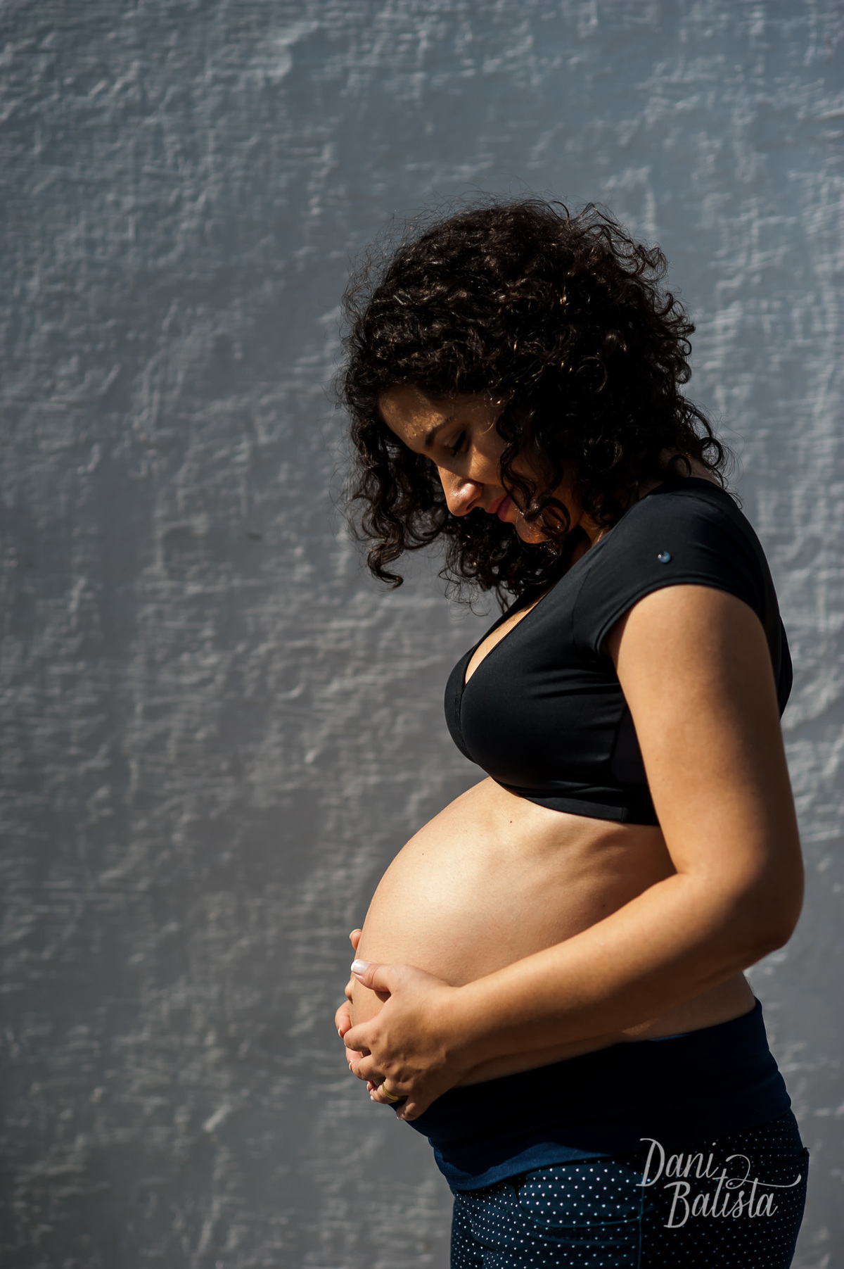 gestante de lado para mostrar a barriga durante ensaio fotografico em niterói