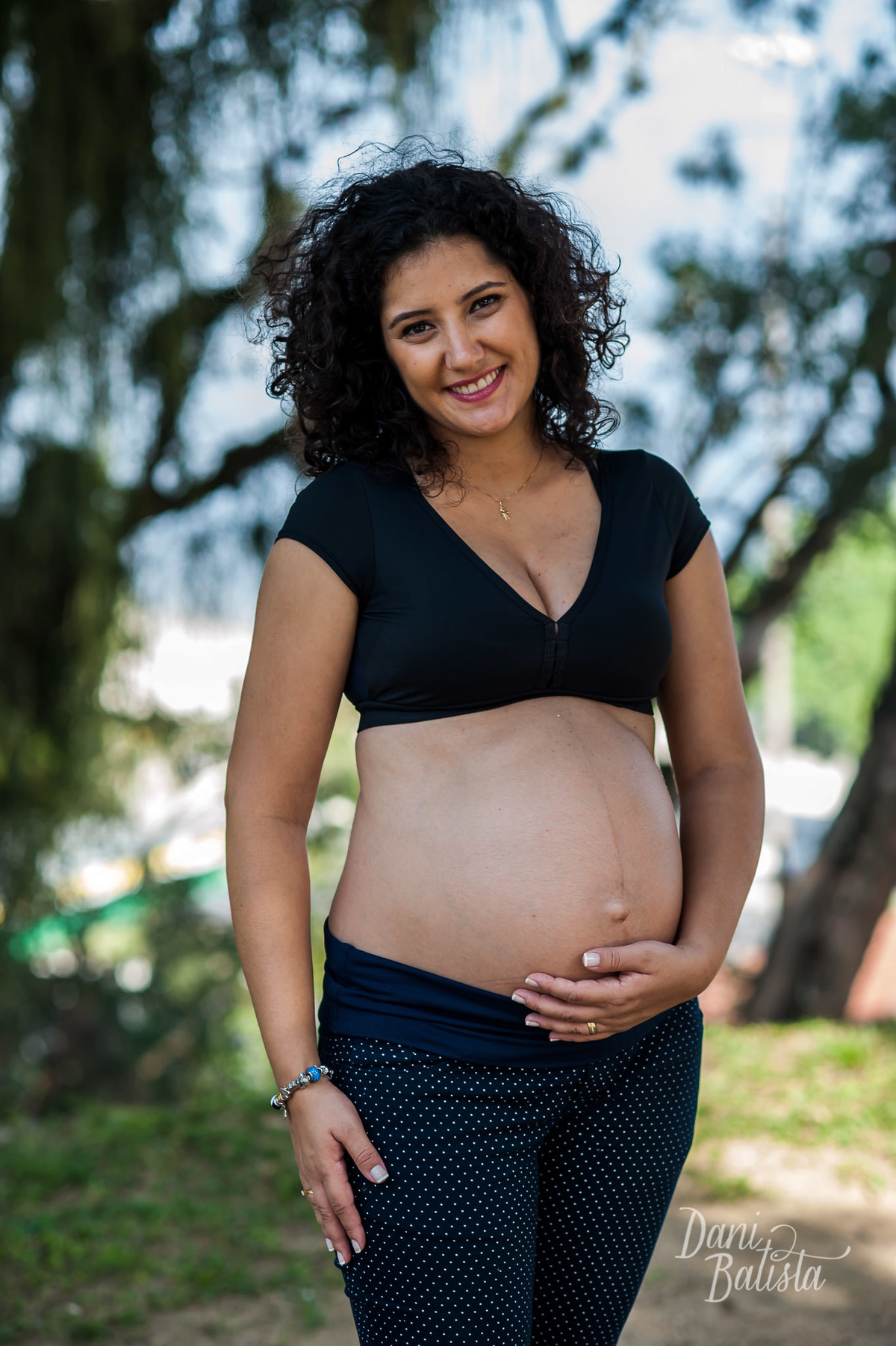 gestante sorrindo mostrando a barriga durante ensaio fotografico em niterói