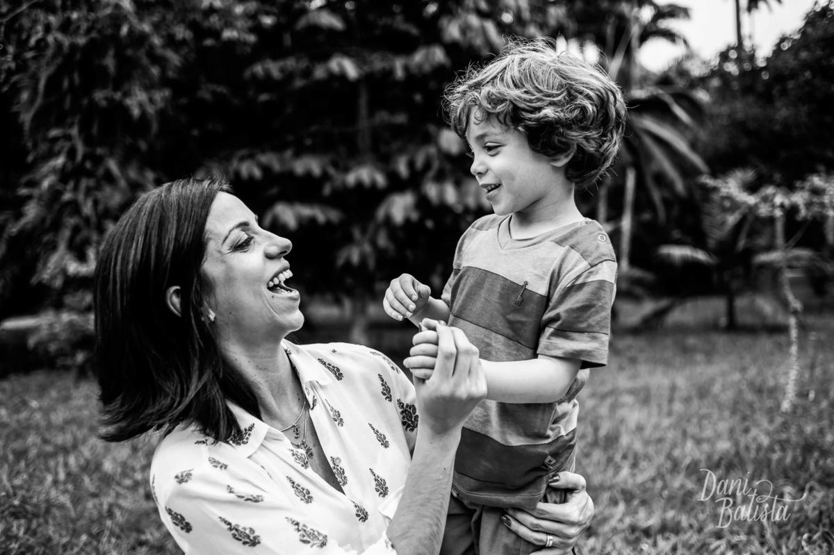 gestante e filho mais velho rindo durante ensaio fotográfico de gestante