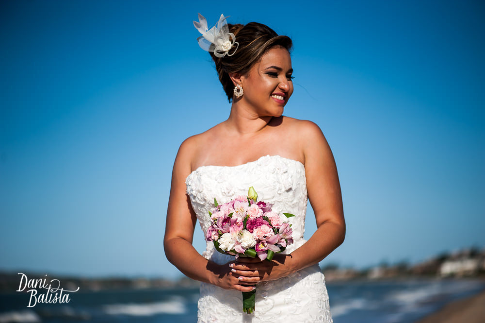 foto da noiva e detalhe do bouquet rosa e fascinator na praia rasa em buzios