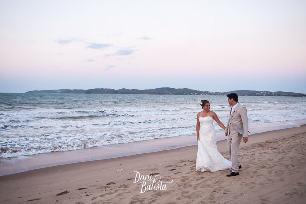noivos caminhando ao pôr-do-sol na praia rasa em búzios antes da cerimônia de casamento