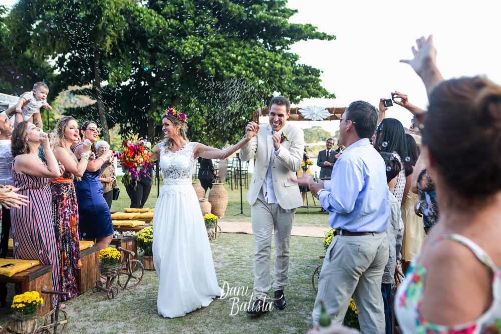 Saída dos Noivos com muito arroz na cerimônia de casamento na praia no forte imbuí