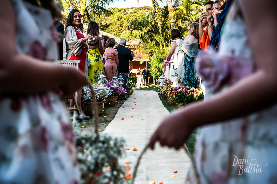 noiva entrando com o irmão na cerimônia ao ar livre na praia da tartaruga em buzios