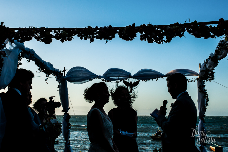 silhueta dos noivos durante os votos no por-do-sol durante cerimônia na praia da tartaruga em buzios