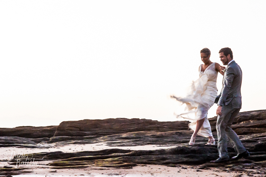 noivos caminhando nas pedras da praia da tartaruga em buzios