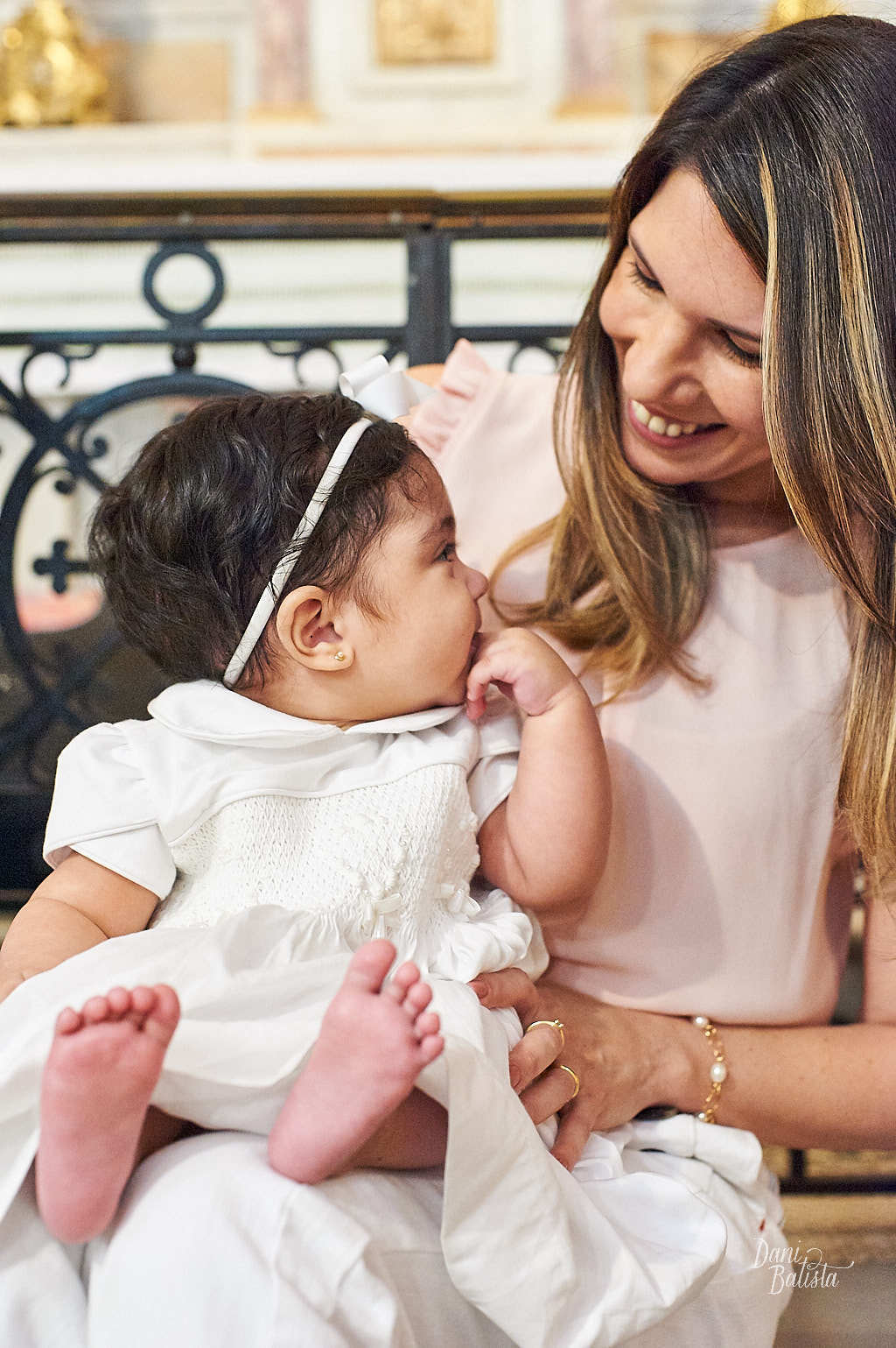 mãe e filha se olhando no batizado infantil